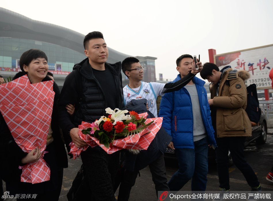 一位女球迷兴奋地展示着刚刚获得的刘炜签名，眼睛笑成了月牙，身旁的同伴投来羡慕的目光。