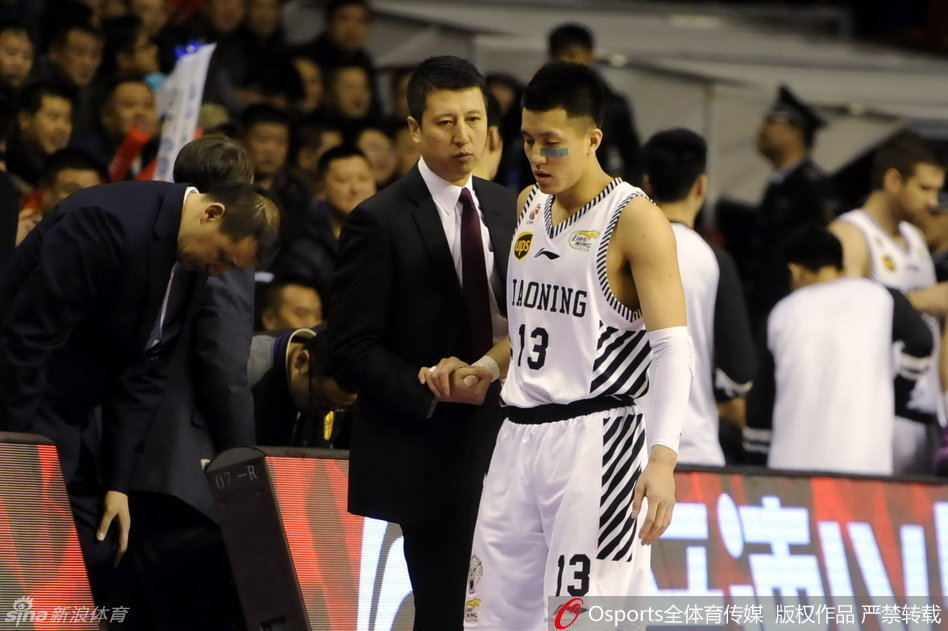 韩德君手臂受伤，表情痛苦地在工作人员搀扶下离场，巨大的身躯此刻显得有些落寞，但他的眼神中依然透露着重返赛场的坚毅。