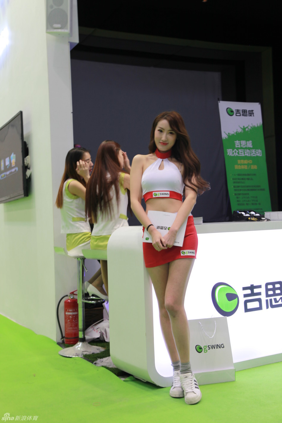 一位气质温婉的展会宣传员手持资料，正微笑着与来宾亲切交谈，展现出专业服务中的亲和力