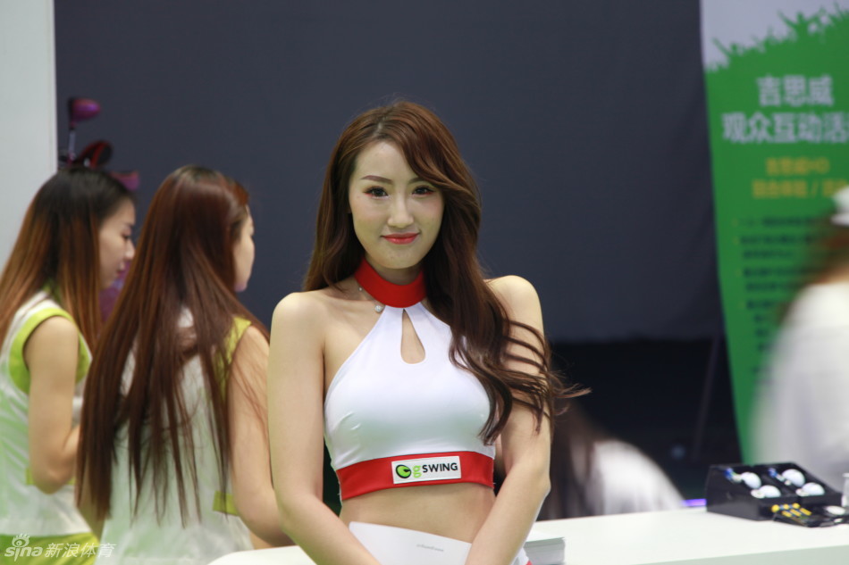 面容妩媚的产品宣传员手持最新款高尔夫球，眼神灵动，正在向客户生动讲解其核心科技