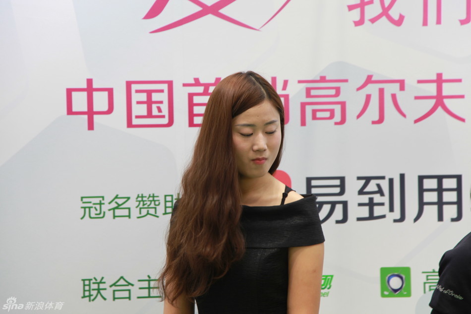 优雅的高球宝贝与来宾一同练习推杆，她的姿势标准，目光紧随球路，共同享受高尔夫运动的乐趣