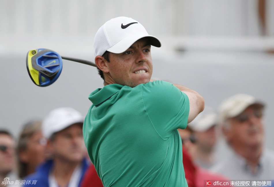 麦克罗伊在果岭上俯身专注地观察小球滚动的路线，眼神锐利，志在必得的神情清晰可见。