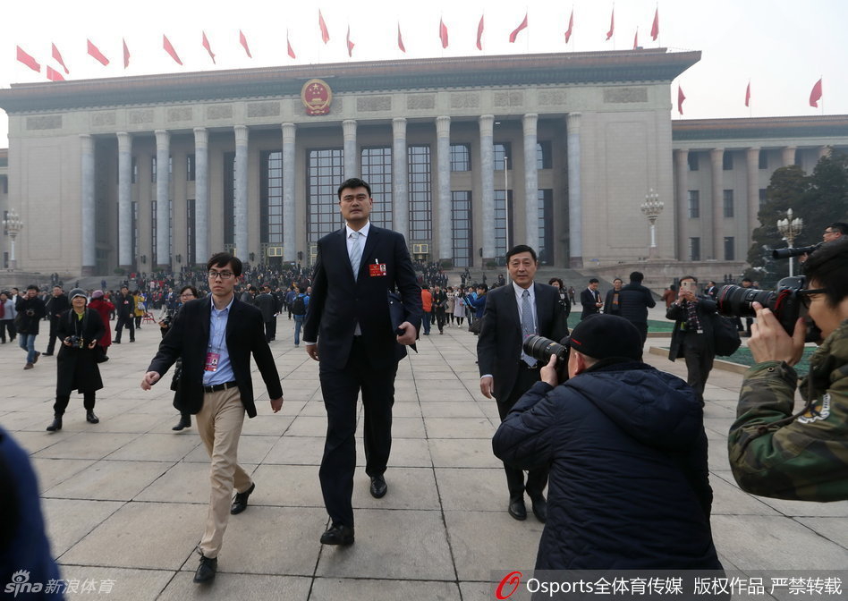 姚明身着深色西装步入会场，神情专注而从容。他手中紧紧握着一份文件，那正是他经过深入调研后精心准备的提案，关乎中国体育产业的未来。