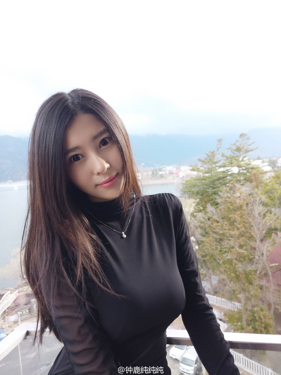 钟鹿纯身穿简约白色上衣，眼神温柔地望向镜头，举手投足间散发着优雅迷人的气质。