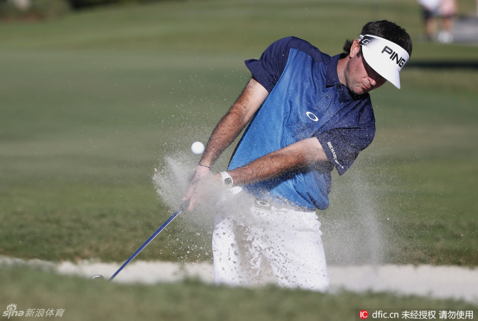 大力球手巴巴·沃森在沙坑中挥杆救球，沙粒飞扬，展现其强大的力量与精湛的短杆技术