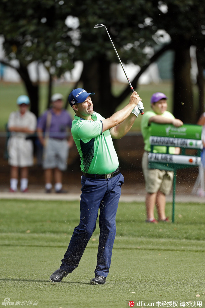 帕特里克·哈林顿在果岭边凝神预备，他的下一次切杆将决定小球能否靠近洞杯，扭转战局。
