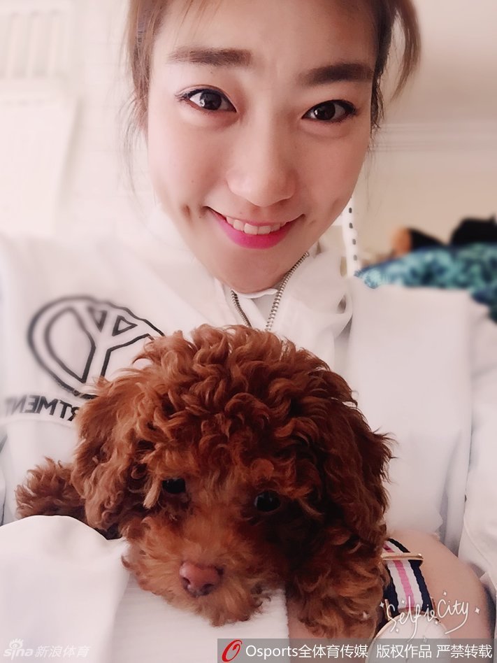 李梦将小泰迪轻轻举起，脸上绽放出明艳动人的自拍笑容，这一刻她不是球场上的明星，只是一个享受生活的阳光女孩