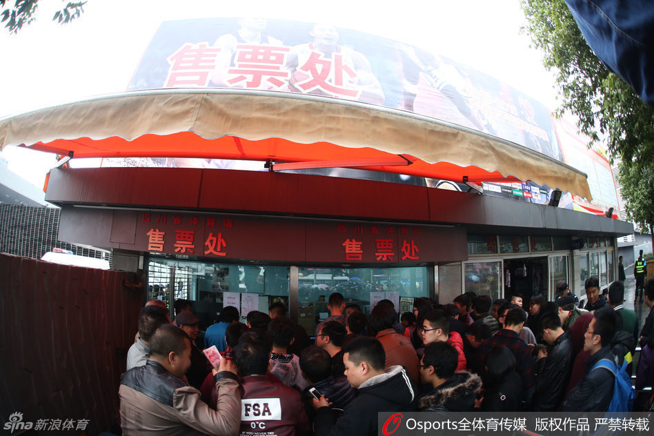 售票人员正在紧张忙碌地进行售票工作，窗口外是无数双急切而渴望的眼睛，每一张递进来的钞票都代表着一份对四川篮球的坚定支持。