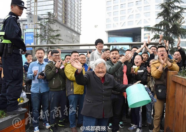 在成功买到球票后，满头银发的孟老太转过身来，面向身后长长的购票队伍。她颤颤巍巍地举起手臂，向那些主动为她让路的数百名热心球迷挥手致意，脸上洋溢着感激与慈祥的笑容，场面温馨而感人。