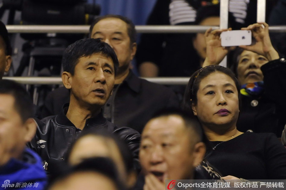 郭艾伦的父亲郭宏坐在看台上，眼神紧盯着赛场上的儿子，面容略显严肃，心中满是对爱子表现的牵挂。