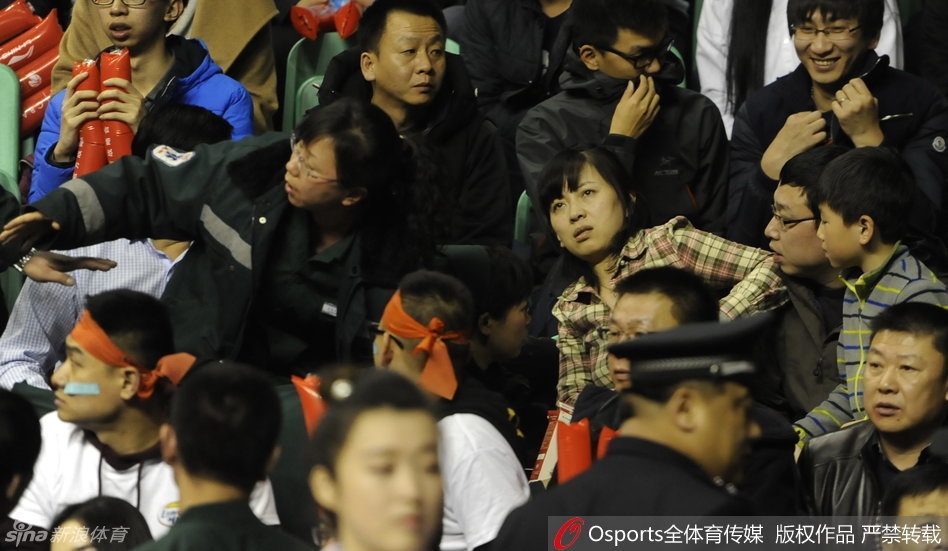 愤怒与混乱之中，辽宁队球员郭艾伦被队友和工作人员紧紧抱住，试图阻止他继续冲向人群，他脸上的表情充满了不解与愤慨。