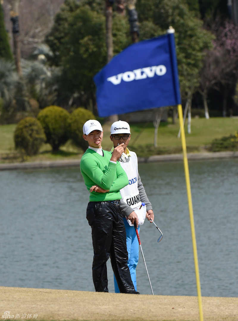 观众聚集在果岭周围，密切关注着球员推杆的紧张时刻