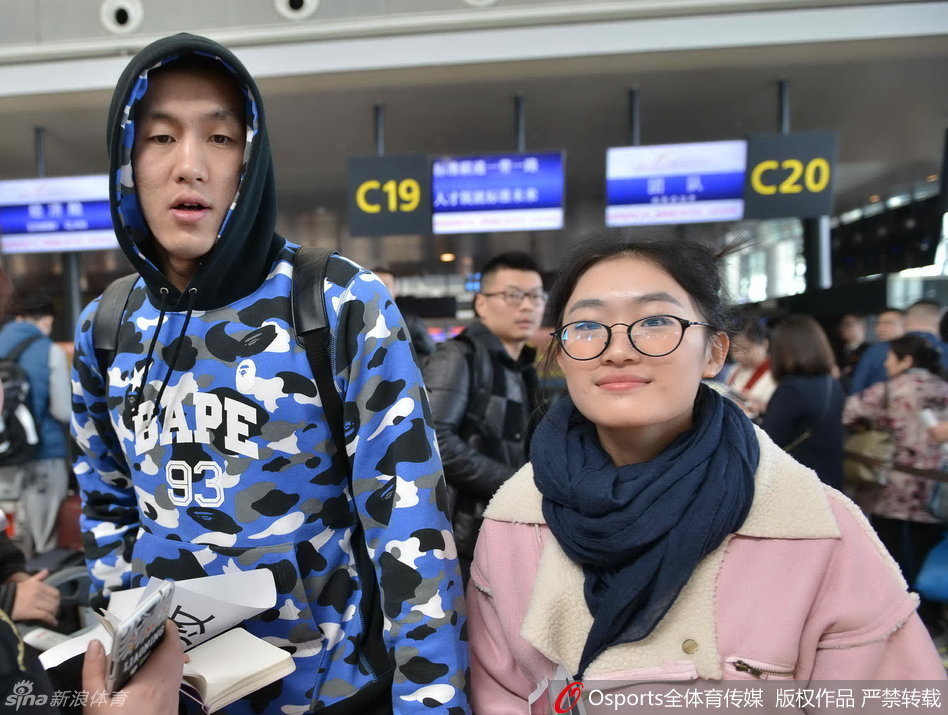 韩德君庞大的身躯背着双肩包，手里紧紧攥着那张通往客场城市的登机牌，像一座移动的铁塔守护着队伍。