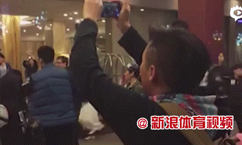 动图画面剧烈晃动，身穿白色队服的辽宁球员与球迷纠缠在一起，手臂挥舞之间满是愤怒，场面极度混乱，分不清究竟是劝架还是争斗。