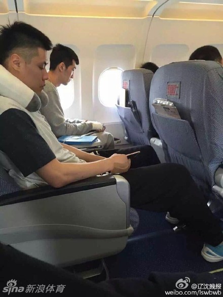 休息室内，贺天举无力地垂下受伤的右手，手腕处包裹着厚厚的医疗绷带，表情落寞而痛苦，身旁的队友低头看着手机，仿佛想从纷乱的信息中寻找一丝平静。