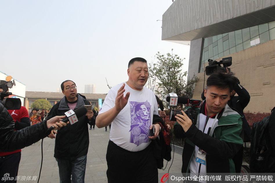 安保人员组成了一道人墙，努力将激动的记者与教练组隔开，其中一名戴眼镜的工作人员神情紧张，用尽全力维持着秩序。