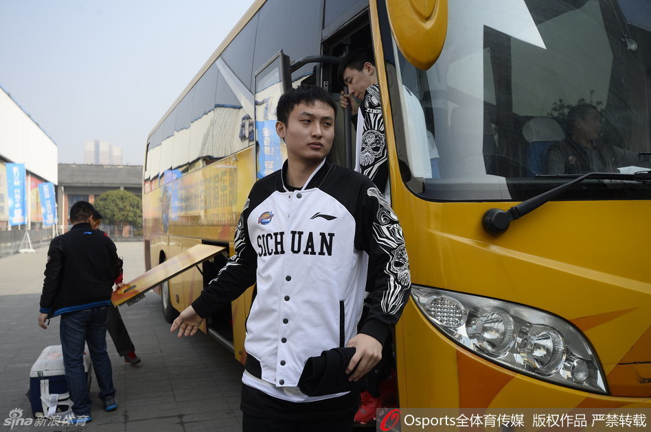 安保人员筑起人墙紧密跟随，目光如炬地守护着四川男篮最后的备战时光，背景中球员的身影显得格外从容与坚定。