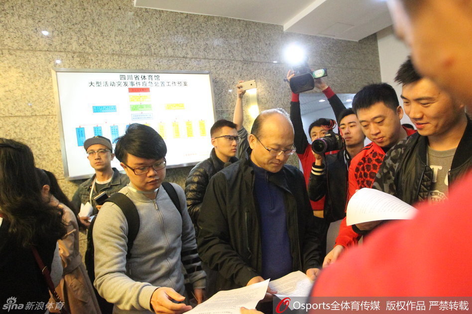 张雄在会议间隙接受采访，身后背景是总决赛的备战氛围，他的表情透露出处理此次棘手事件的复杂心情。