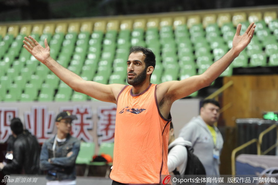 哈达迪穿着白色T恤在进行投篮训练，神情专注，巨大的手掌稳稳托住篮球，仿佛托起了整个四川篮球的希望，脸上带着刚睡醒般的憨厚笑容。