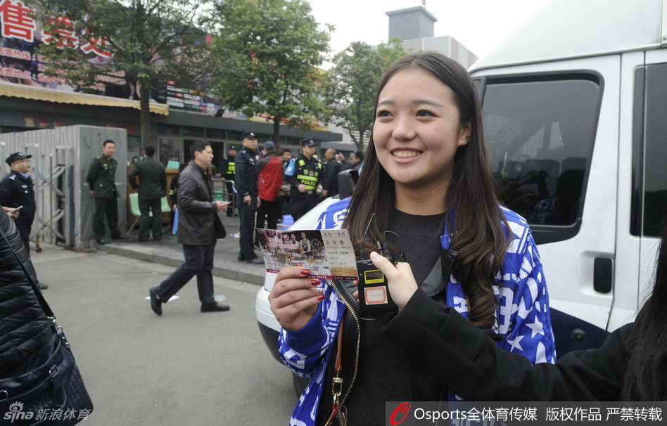 一位女球迷在深夜的排队人群中，终于将这张来之不易的总决赛门票紧紧握在手中，脸上绽放出如获至宝般的灿烂笑容，眼中闪烁着期待与激动。