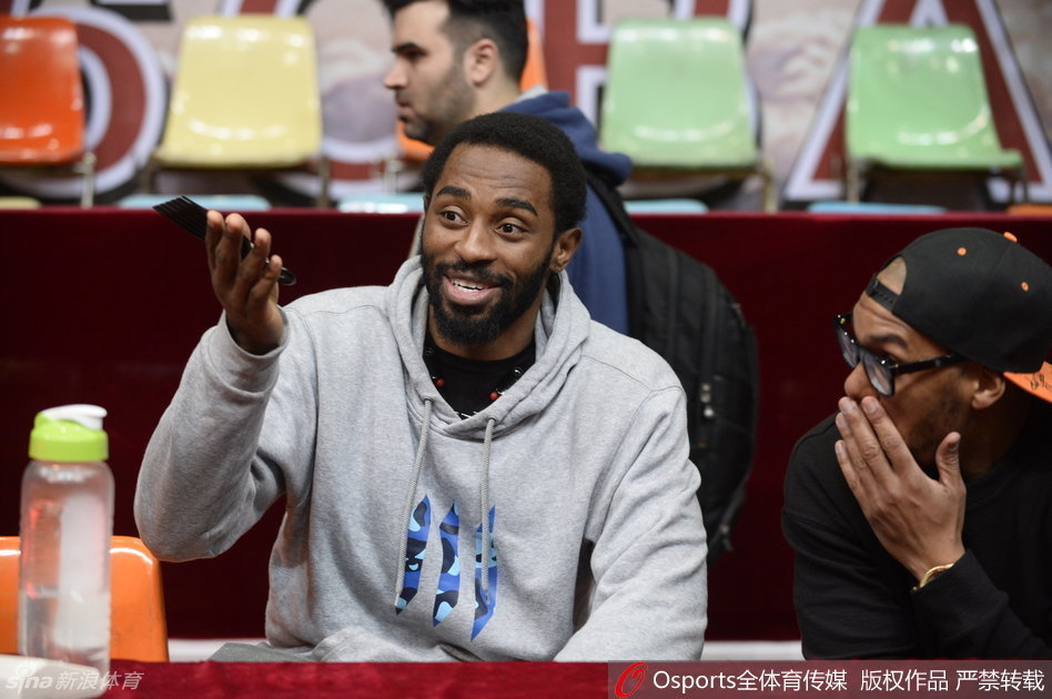 哈里斯在教练身后挤眉弄眼，将手搭在杨学增指导的肩上，做出夸张的鬼脸，而杨指导则一脸严肃地指挥战术，形成了极具戏剧性的师徒反差萌