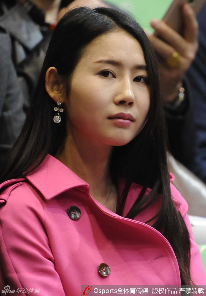 辽宁男篮球员贺天举坐在观众席上，身着便装，眼神中透露出对比赛的渴望和对队友的关切