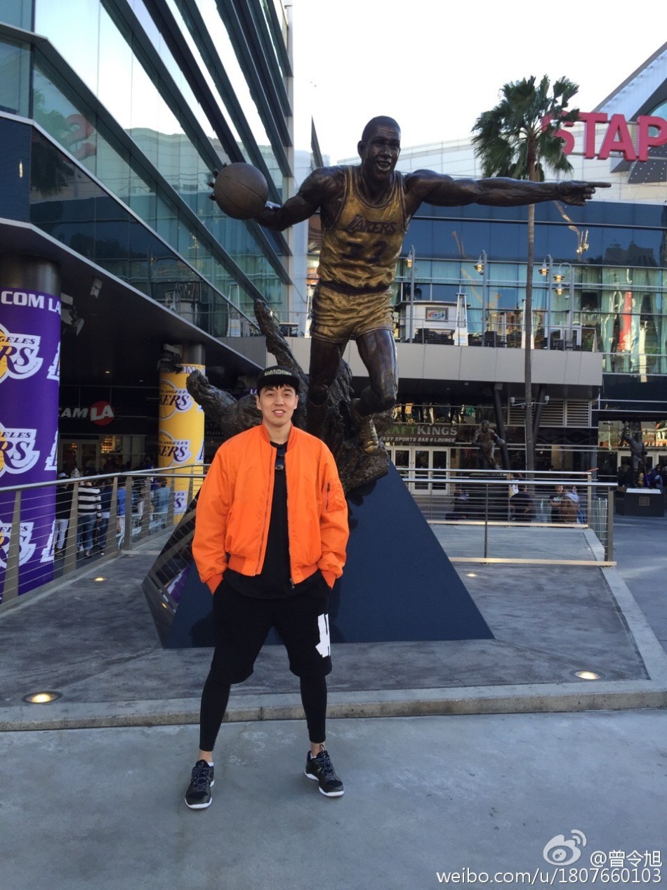 曾令旭模仿着魔术师约翰逊铜像的神韵，在斯台普斯广场前留下一张跨越时空的合影，仿佛在汲取NBA传奇控卫的篮球智慧