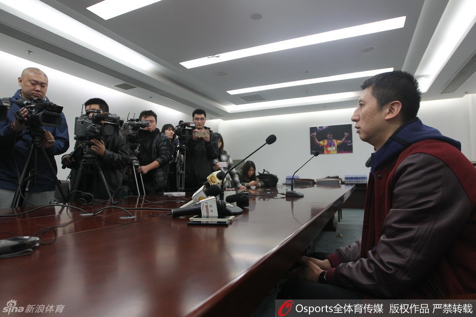 场边的郭士强手拿战术板，神情专注地望向球场，眼神中透露出对胜利的渴望和对场上局势的精准判断。