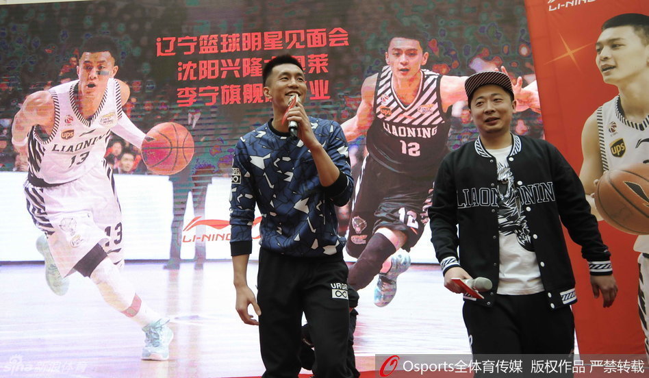 身着浅蓝上衣的杨鸣露出阳光笑容，身旁的礼仪小姐被他帅气的侧颜所吸引，眼神中流露出一丝羞涩与惊叹。