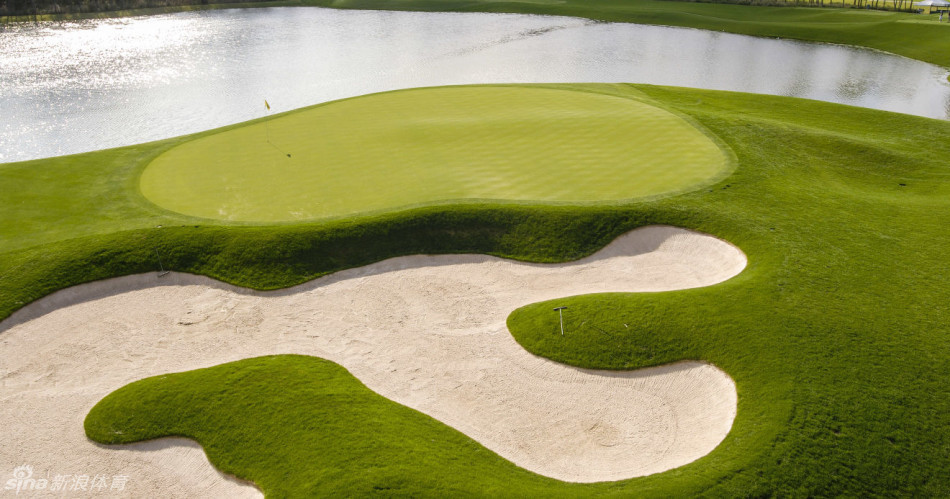 夕阳下的第十八洞全景，发球台、球道与俱乐部会所沐浴在金色余晖中，宛如一幅古典油画