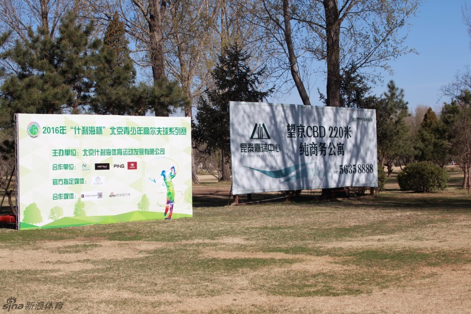 一位身穿红色上衣的少年选手在开球区优雅转身挥杆，白色小球应声而起，飞向远方湛蓝的天空与翠绿的球道。