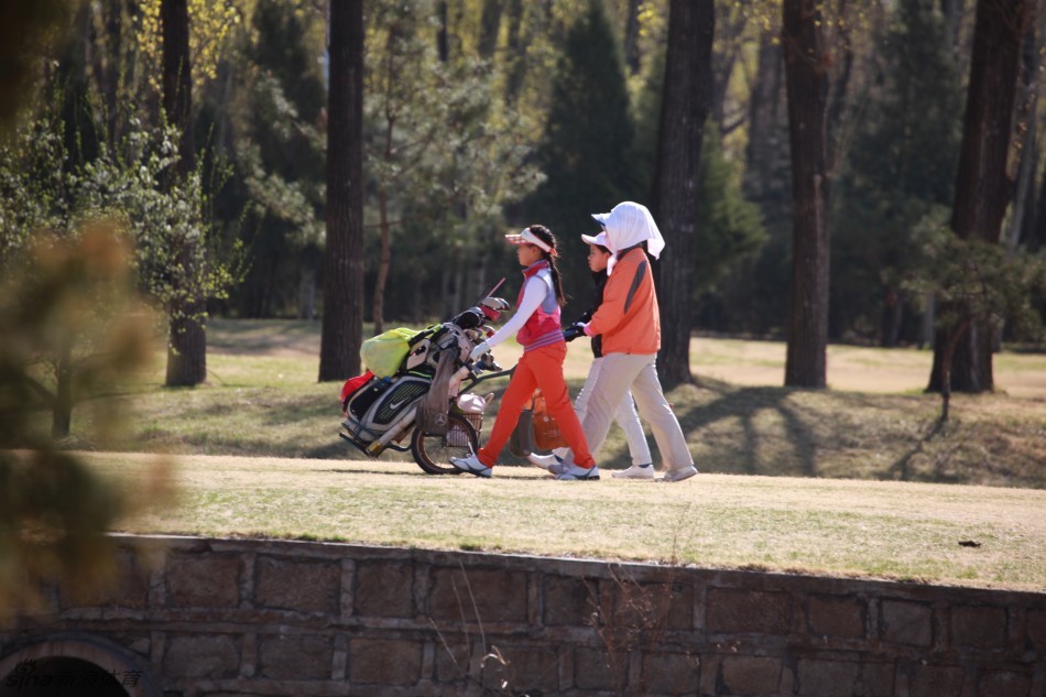 一位戴着白色遮阳帽的女孩选手在沙坑中成功击出一记漂亮的救球，沙粒飞扬的瞬间，捕捉到了她技术动作的流畅与力量。