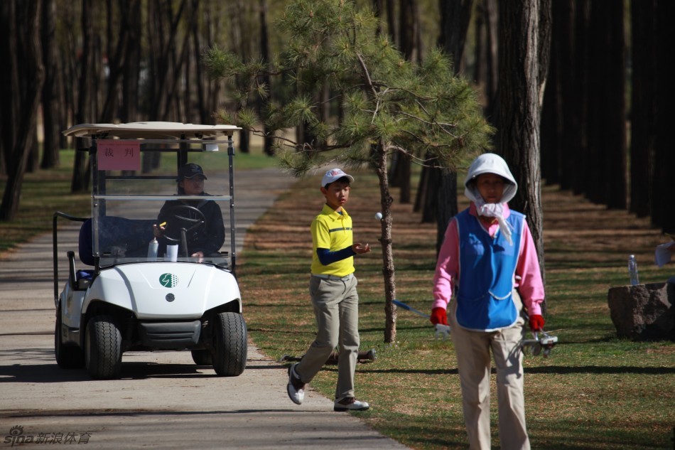 一位小女孩选手凝神静气，正准备推杆，她沉稳的姿态和坚定的眼神，完全看不出年幼的稚嫩，只有对胜利的专注渴望。