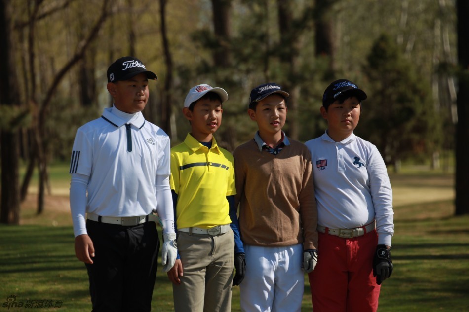 两位小选手在果岭边并肩而行，一边认真观察球路，一边进行着热烈的战术讨论，展现出伙伴间的默契与专注。