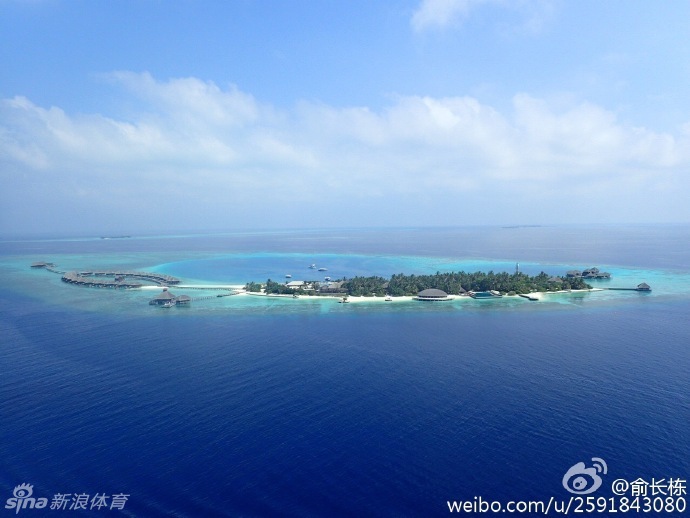 俞长栋与妻子在马尔代夫的海边甜蜜相依，身后的夕阳将两人的身影拉长，他脸上洋溢着幸福满足的微笑，画面温馨如画。