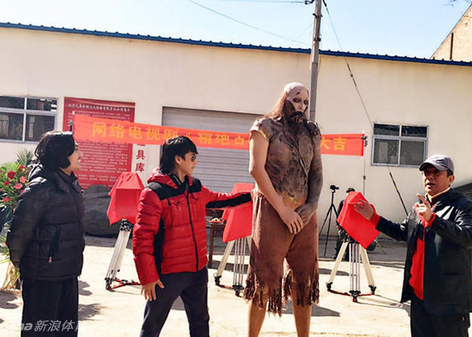 在灯光明亮的拍摄现场，孙明明身穿厚重残破的‘红犼’戏服，正在听从导演的调度。那布满伤痕的后背和粗壮的臂膀，在专业灯光下显得格外真实，仿佛一个真正的古墓巨兽即将挣脱束缚，扑向它的猎物。