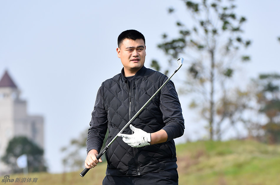 姚明与曾志伟在球场上并肩而立亲切交流,巨大的身高差构成幽默画面,尽显跨界赛事的轻松与友谊。