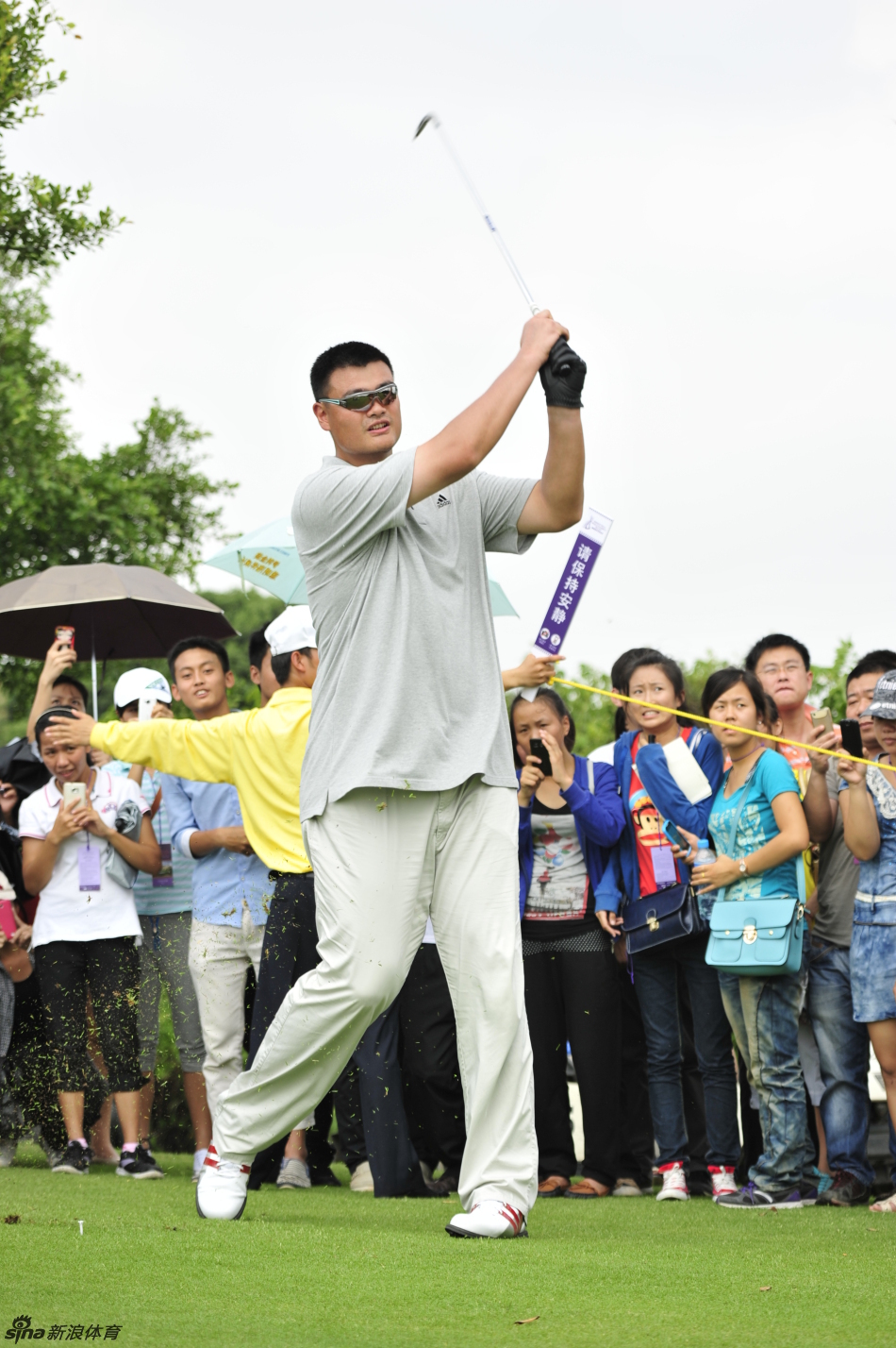 姚明在果岭上俯身仔细观察推杆线路,表情严肃认真,果岭的起伏尽在他巨人的计算之中。