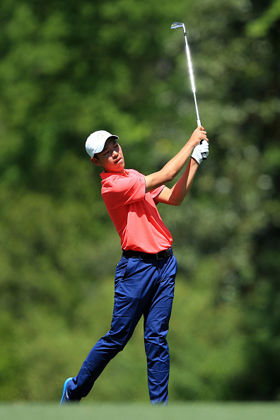 金诚在开球台上沉稳挥杆，身后是奥古斯塔标志性的巨大树冠与如画风景