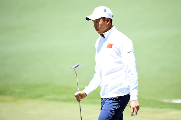 金诚面对挑战性推杆深呼吸，奥古斯塔标志性的果岭旗在微风中轻轻飘动