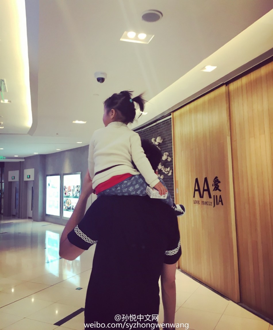 午后的休闲时光，孙悦戴着墨镜尽显酷爸本色，怀中的小月亮穿着可爱的碎花裙，好奇地打量着镜头，父女俩同框的画面既有型格又有爱意，反差感十足。