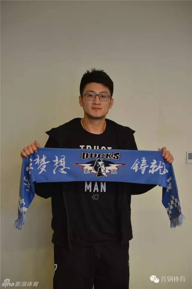段江鹏小心翼翼地将北京男篮的围巾捧在手中，仔细端详，红色的围巾映衬着他眼里的期待，仿佛已经感受到京城球迷的呐喊。