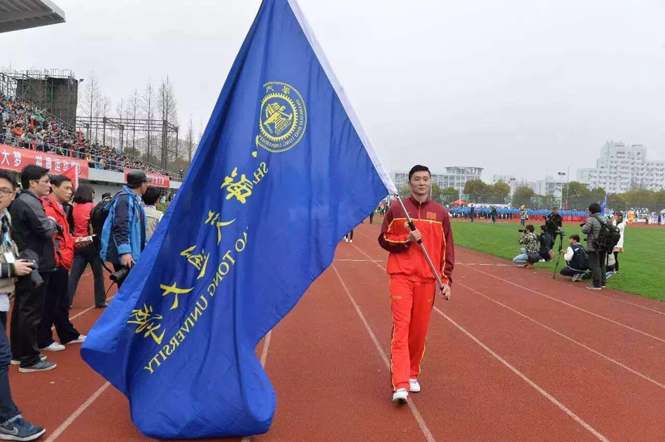 篮球名将刘炜作为旗手，高举上海交大运动会会旗，带领方阵步入会场，目光坚毅，英姿勃发。