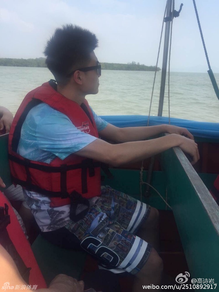 高诗岩与父亲并肩坐在小船上，两人手握船桨，脸上洋溢着轻松惬意的笑容，享受着海面上的亲子时光