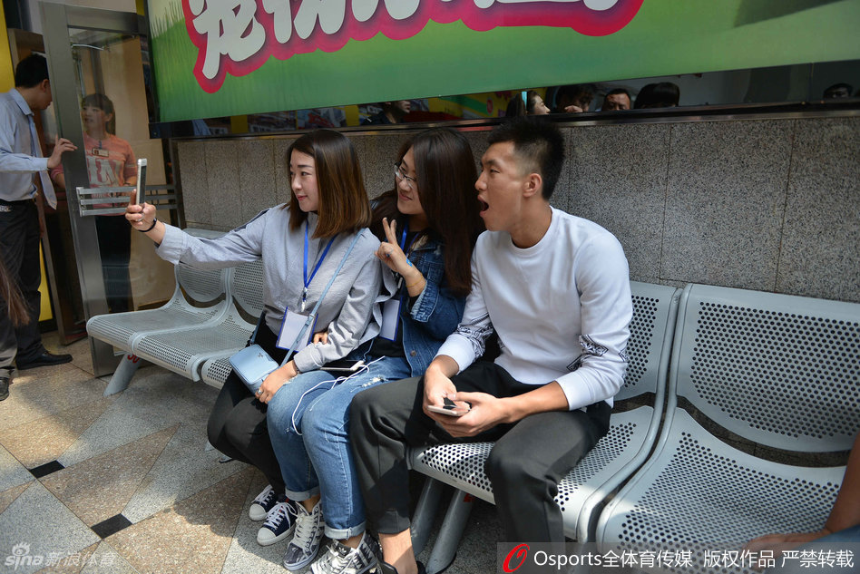 郭艾伦耐心地与场边的小球迷交流互动，弯下高大的身躯，仔细聆听小朋友说话。