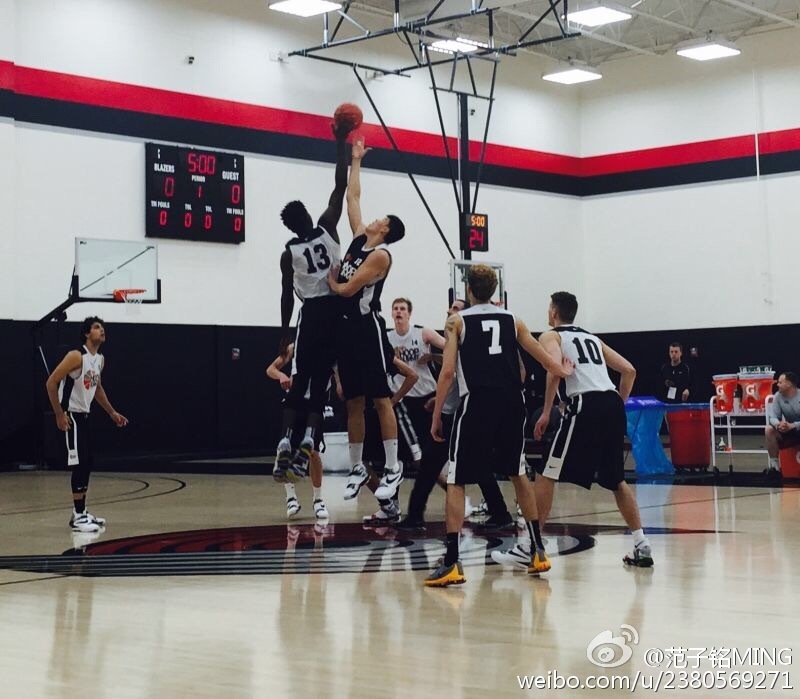 身穿国际队红色战袍的范子铭在赛前热身中神情专注，拉伸筋骨，为即将到来的激烈对抗做着最后准备。