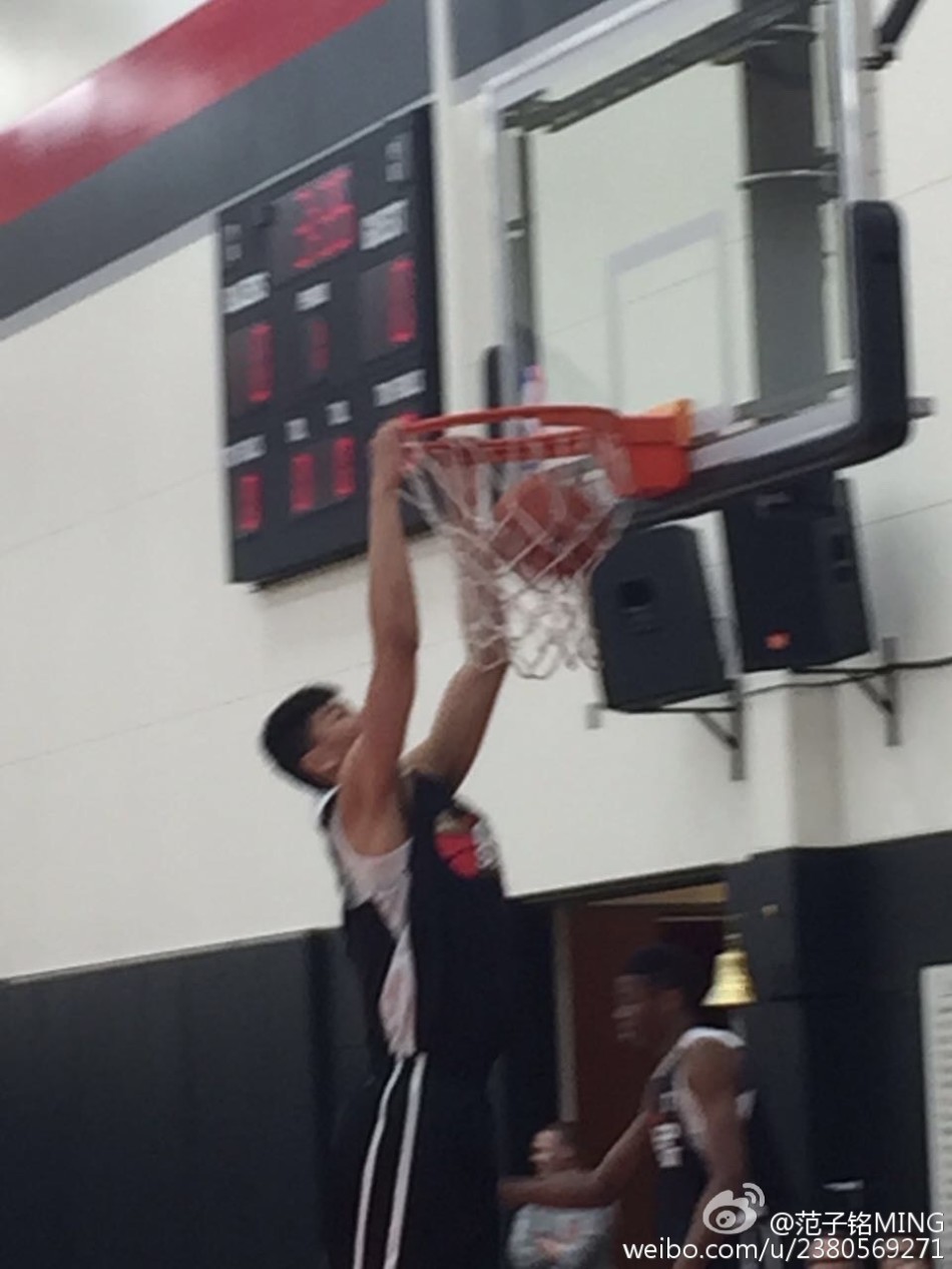 比赛结束后，范子铭与辽宁队主教练郭士强在场边亲切合影，两人面带微笑，背后是波特兰球馆的看台。