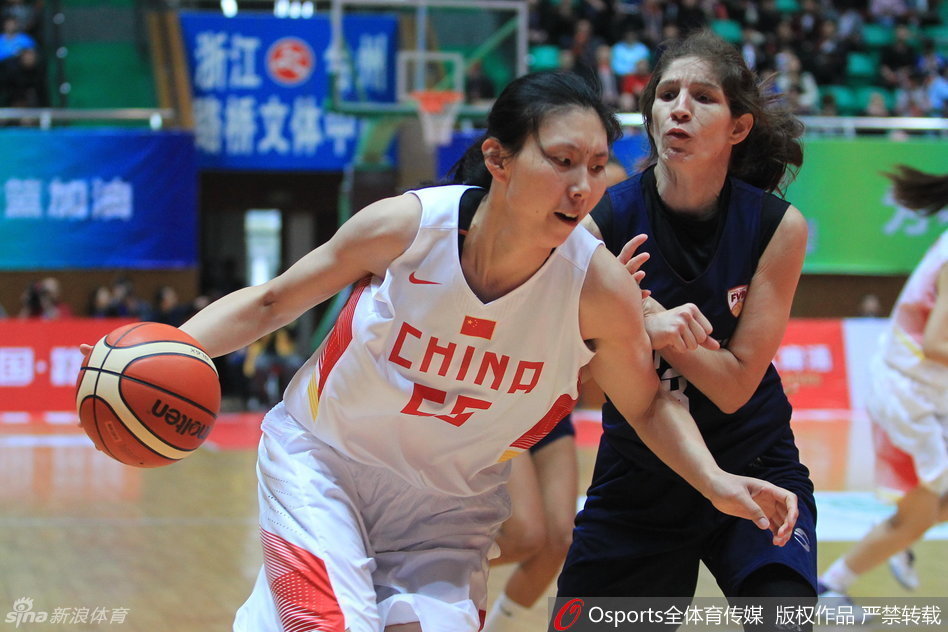 面对高大防守队员的封盖，女篮队员毫无惧色，她压低重心，利用节奏变化持球摆脱，试图撕裂对手的双人联防防线。