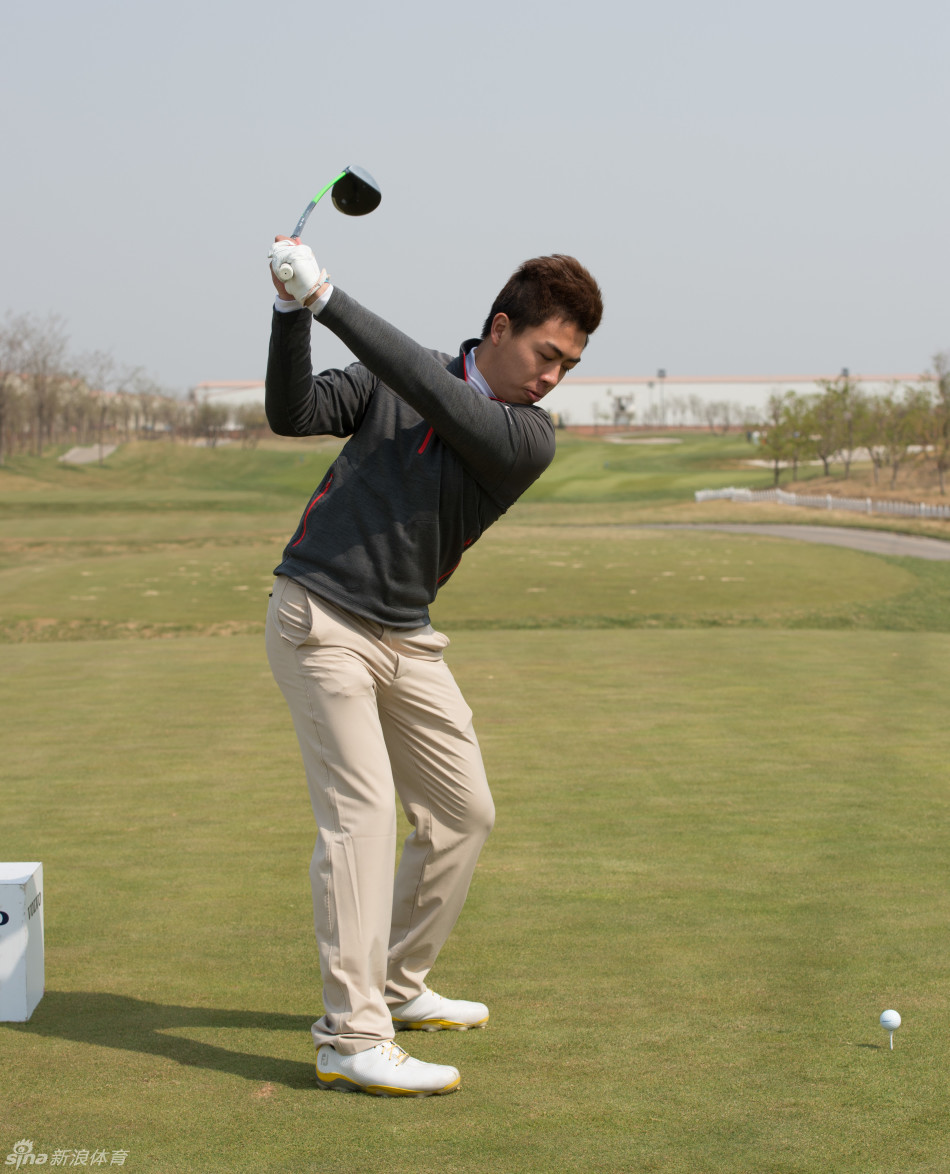 佘梓瀚在发球台侧身瞄准，神情严肃，仿佛正在计算着风速与落点