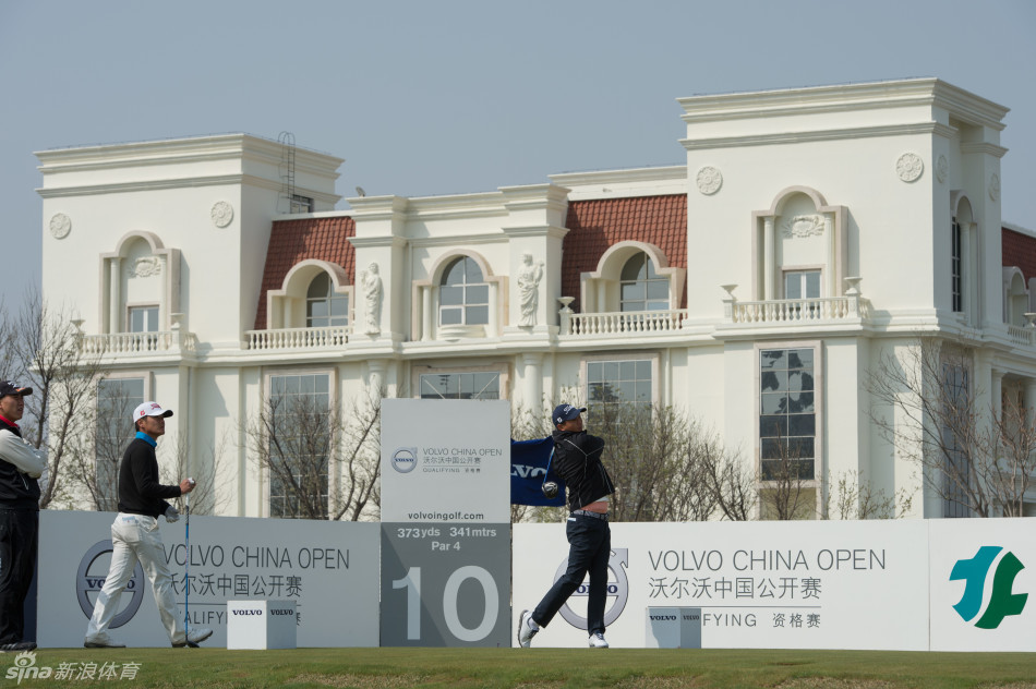 阳光洒在整洁的赞助商车队上，与远处宁静的球场相映成趣，烘托出大赛前的宁静氛围